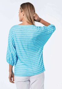 Hellblauer Pullover mit weißen horizontalen Streifen, locker sitzenden Fledermausärmeln und einem runden Ausschnitt. Weiches Baumwollmaterial.