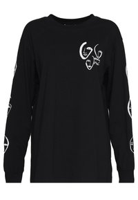 Black long-sleeve t-shirt made from cotton, featuring white abstract face designs on the front and sleeves, and a round neck.