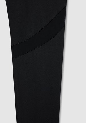 Leggings sportivi neri realizzati in un tessuto liscio, con un dettaglio di fascia in mesh testurizzata in un motivo diagonale.