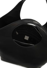 Svart läder tote-väska med rundad form, med en ficka som går att stänga med dragkedja invändigt och en slät yta. Minimalistisk design med en detalj i silver-logotyp.