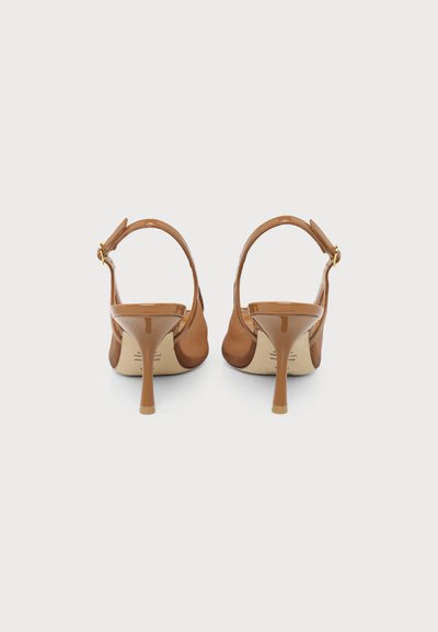 Paire d'escarpins slingback en cuir verni beige avec bouts pointus et talons aiguilles fins, vus de dos sur fond blanc.
