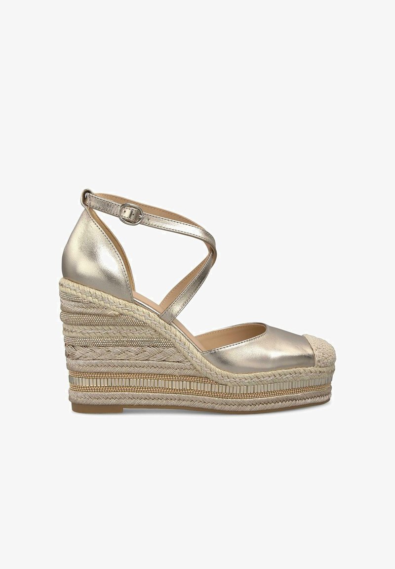 Metallic gold espadrille wedge sandals with a closed toe, cross-strap ankle design, and woven jute platform midsole. Flat rubber outsole.
