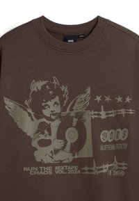 Sudadera marrón de Vans con una gráfica de un querubín alado sosteniendo un disco de vinilo, estrellas y el texto "Corre la Mixtape del Caos Vol. 2024."