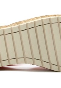 Shoe sole features a textured beige rubber base with vertical ridges and a natural fiber accent around the edge.