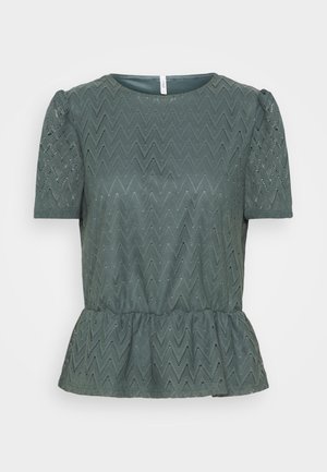 Blouse verte à manches courtes avec un motif en dentelle en zigzag, col rond, manches bouffantes et ourlet en basques froncées.