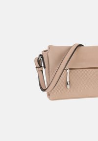 Borsa a tracolla in pelle beige con texture perforata, tracolla regolabile, tasca con zip e dettagli in metallo argentato. Forma rettangolare compatta.