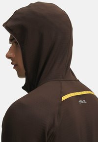 Brown hooded athletic top with textured fabric, featuring a yellow accent stripe and a reflective logo on the back.