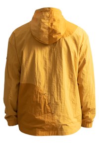 Geel hoodie-jack gemaakt van lichtgewicht stof. Heeft een gebogen ontwerp, een gestructureerd oppervlak en decoratieve stiksels aan de zijkant.