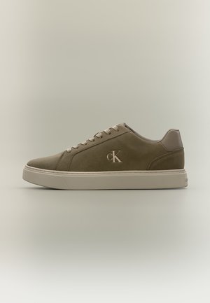 Παπούτσι τύπου sneaker χαμηλού προφίλ σε ελιά χρώμα με μπεζ σόλα, κορδόνια και λογότυπο "cK" στο πλάι, εμφανίζεται σε προφίλ σε ουδέτερο φόντο.