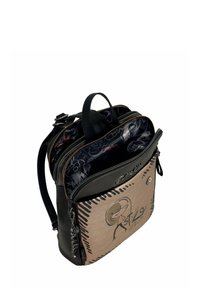 Zaino con parte superiore in pelle nera e sezione inferiore beige con motivo stampato. Due zip si aprono per rivelare un interno decorato.