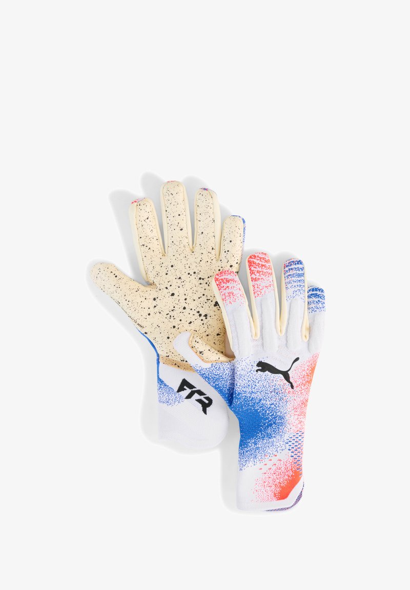 Une paire de gants de gardien de but avec un design moucheté blanc, bleu et rouge, un logo Puma noir, et des paumes de préhension beiges avec des mouchetures noires.