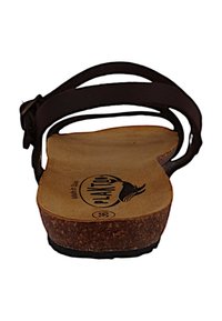 Sandal de tiras marrón con una plantilla de corcho, que muestra una textura suave, hebilla ajustable y un logo en relieve en la plantilla.