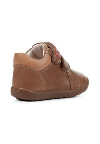 Scarpa in pelle marrone con punta arrotondata, altezza della caviglia bassa, cinturino in Velcro e suola in gomma. Presenta dettagli testurizzati e marchio Geox.