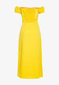 Vestido amarillo sin mangas hecho de tejido suave, con un corsé ajustado de textura fruncida y una falda fluida.