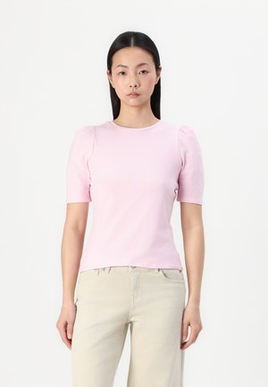Tricou din bumbac de culoare roz pal, cu mâneci scurte tip puff, guler rotund și croială ajustată. Textură fină, asortat cu pantaloni bej.