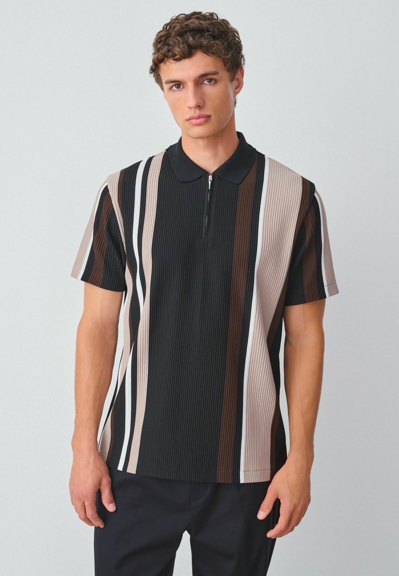 Camisa polo de manga corta con rayas verticales en negro, marrón y beige. Tejido texturizado con cuello y detalle de media cremallera.