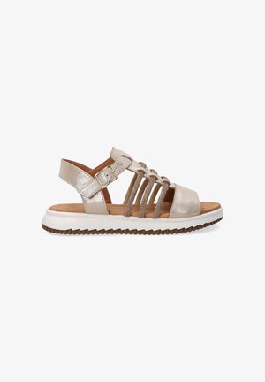 Metalen gouden sandaal met open teen, kruislings straps, verstelbare gesp en witte zool met een gestructureerde bruine onderkant.