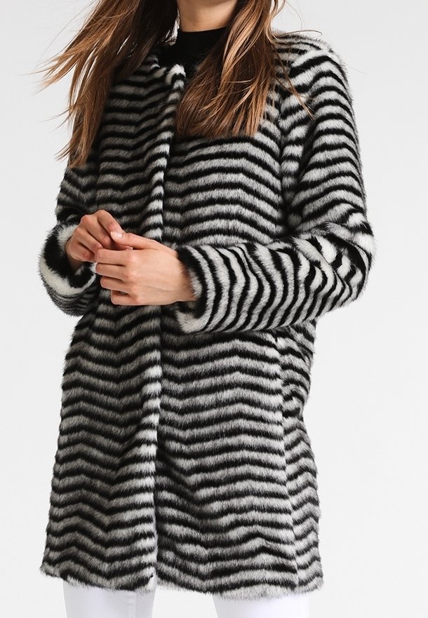 Cappotto in pelliccia sintetica con motivo a righe nere e bianche, di lunghezza media, texture morbida, colletto rotondo e design aperto davanti.