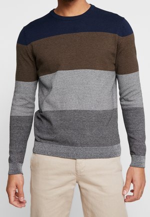 Neulottu villapaita, jossa on vaakasuorat raidat tummansinisestä, ruskeasta, harmaasta ja vaaleasta harmaasta. Pyöreä kaula-aukko, pitkät hihat sekä ribbattu helma ja hihansuut.