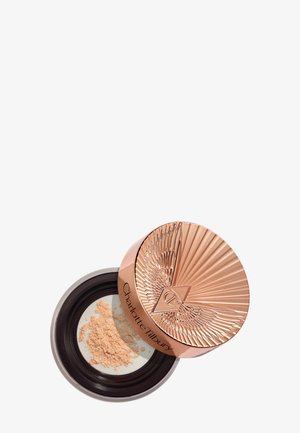 Offener Behälter mit losem beigem Gesichtspuder und einem roségold texturierten Deckel, graviert mit dem Markennamen und Logo von Charlotte Tilbury.