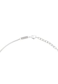 Sølv kædearmbånd med et poleret metaltag, der har en krabbe-lås og små ovale led, som viser en skinnende finish.