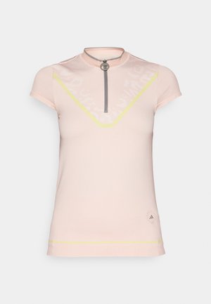 Tricou sportiv de culoare roz deschis, cu guler înalt și mâneci scurte. Dispune de un fermoar frontal, accente galbene și un design subtil cu modele.