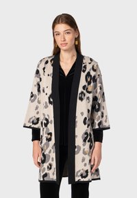 Leren jasje met luipaardprint in beige, zwart en grijs, met een open voorkant, kimono-mouwen en contrasterende zwarte afwerking. Zachte brei-textuur.