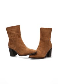 Botas de tobillo de ante marrón con punta afilada y tacón cuadrado. Textura suave, con un eje de altura media y diseño minimalista.