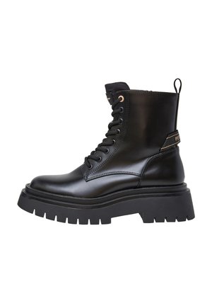 Zwarte leren enkelboot met een gladde afwerking, ronde neus, veters en een dikke zwarte loopzool met profiel. Voorzien van een trekhaak en logo-detail.