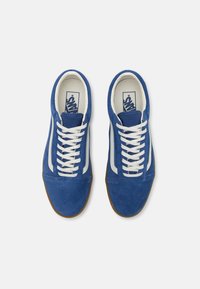 Chaussures en cuir suédé bleu avec des lacets blancs et des accents sur les côtés. Semelle en caoutchouc, col rembourré et détails perforés sur la languette.