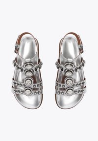 Sandali argento con più cinturini, adornati con elementi circolari che presentano pietre trasparenti e nere, design con punta aperta.