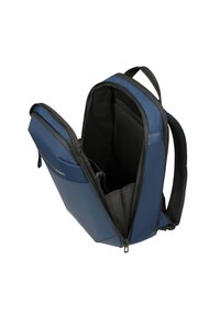 Zaino in tessuto blu scuro con superficie liscia, dotato di apertura con zip, interno in rete e sezioni imbottite per l'organizzazione.
