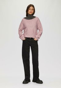 Jasnoróżowy, oversize sweter o ribbowej strukturze, z szerokim dekoltem, nałożony na ciemnoszary golf. W zestawieniu z czarnymi spodniami prostymi i masywnymi butami.