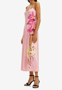 Vestido sin mangas de color rosa con un estampado floral de orquídeas y conchas marinas. Tejido suave, diseño hasta el tobillo y una silueta relajada.
