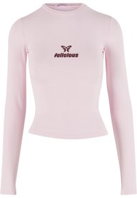 Langermet, tettsittende topp i myk pastellrosa stoff med rund hals og en brun "felicious"-logo i midten, med et sommerfugldesign.