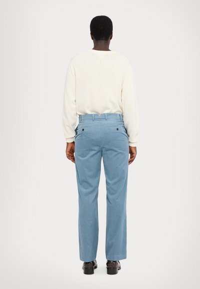 Blue corduroy pants with a relaxed fit, featuring a high waist and two back pockets with black buttons. Complemented by a light sweater.