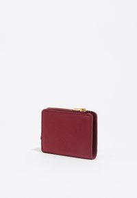 Cartera de cuero burdeos con un acabado texturizado, cierre de cremallera y herrajes dorados. Forma rectangular compacta con líneas limpias.