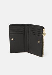 Black leather wallet with gold hardware, featuring multiple card slots, a zip closure, and a smooth texture. Interior is unembellished.