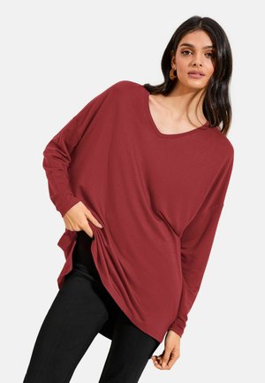 V-Ausschnitt, langärmeliges Oberteil in tiefem Burgunderrot, gefertigt aus einem weichen Stoff, mit lockerer Passform und seitlichen Schlitzen für mehr Bewegungsfreiheit.