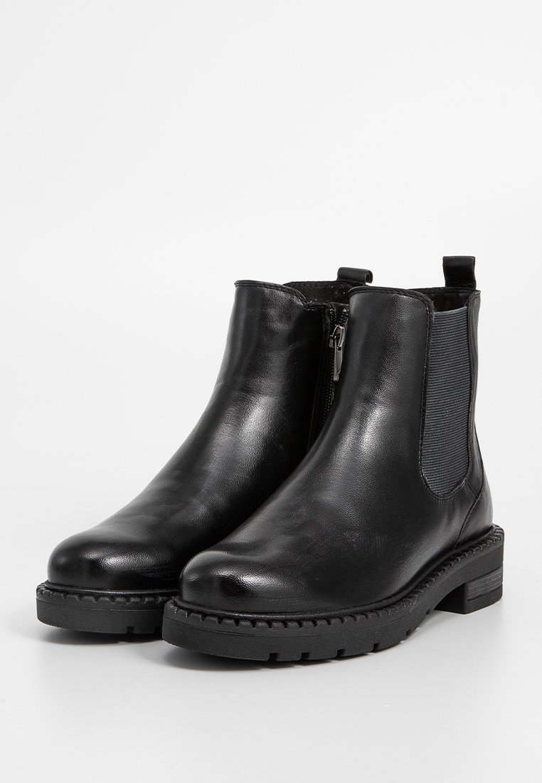 Botas de cuero negro hasta el tobillo con paneles elásticos laterales, cierre de cremallera y suela de goma negra texturizada para mayor agarre. Acabado liso con costuras reforzadas.