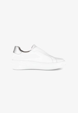 Baskets blanches à enfiler avec semelle épaisse et languette arrière argentée, vue de côté sur un fond blanc uni.