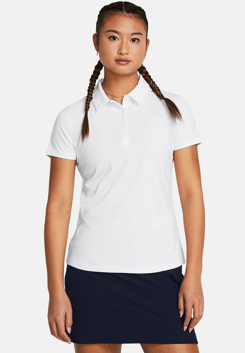 Polo bianco con colletto e tre bottoni, realizzato in tessuto liscio. Indossato con una gonna blu scuro; il modello presenta capelli intrecciati.