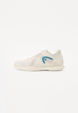 Scarpa atletica leggera in bianco sporco con tomaia in rete testurizzata, logo di accento blu e suola in gomma con motivi di grip.