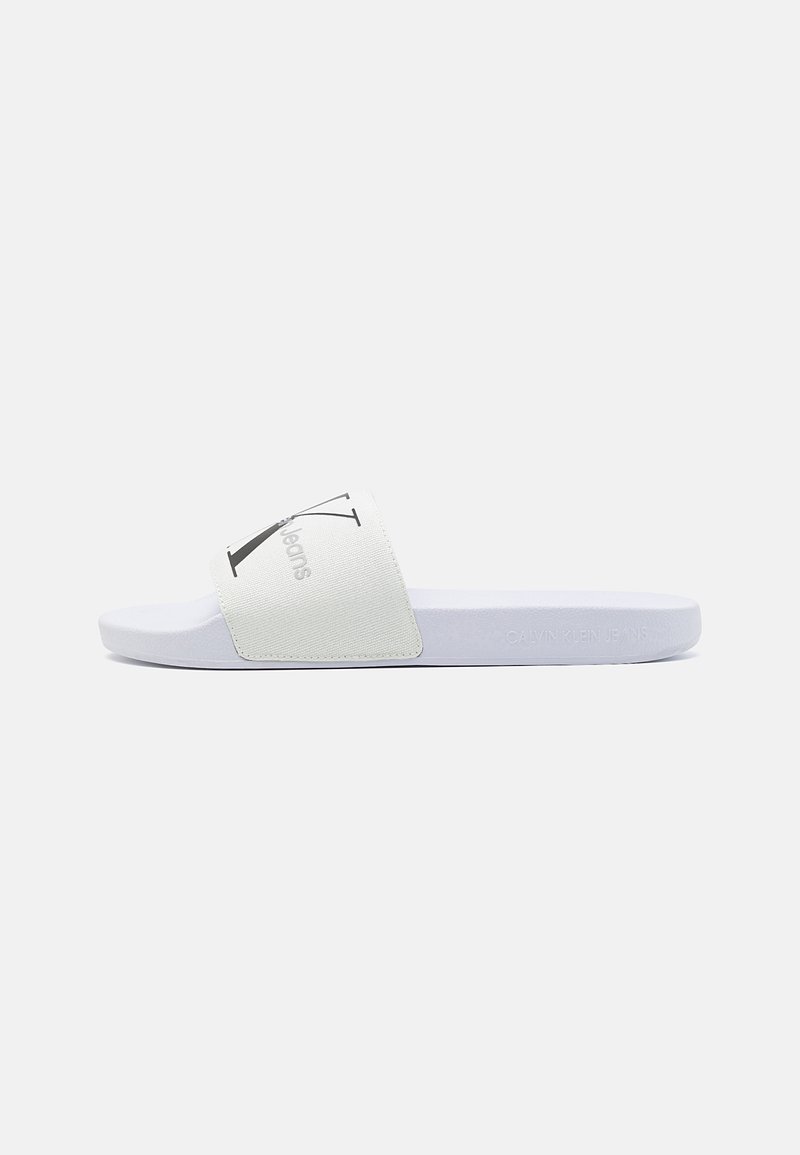 Sandale à glissière blanche avec une bride en tissu ornée d'un logo noir. La semelle est d'un bleu clair uni, à la texture lisse et au design minimaliste.