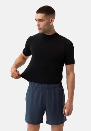 Černý top s krátkým rukávem a vysokým límcem, vyrobený z elastického materiálu. Pairs s tmavě modrými šortkami s elastickým pasem.