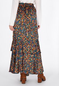 Gonna maxi con stampa floreale multicolore, caratterizzata da strati arricciati, cintura elastica e un design fluente. Realizzata in tessuto leggero.