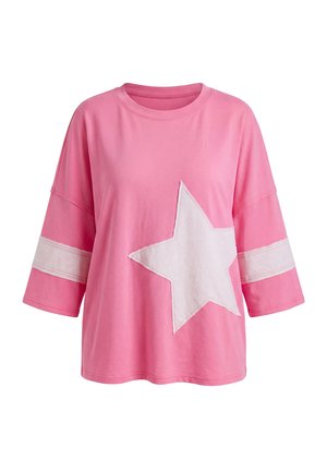 Top roz rozî cu mâneci trei sferturi supradimensionat, cu o stea albă în față și dungi albe în jurul mânecilor.