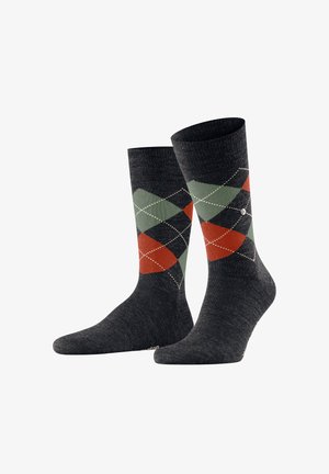 Dunkelgraue Socken mit einem Argyle-Muster in Grün, Rot und Schwarz, mit weißen Akzenten. Das Material ist strukturiert und weich.