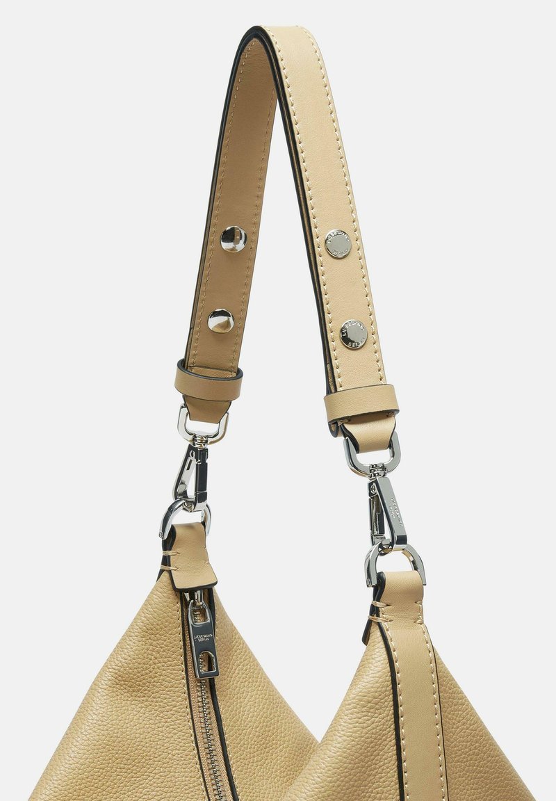 Beigefarbener Lederhandtaschenriemen mit strukturiertem Finish, ausgestattet mit Metallbeschlägen und einem Reißverschluss, akzentuiert mit schwarzen Kanten und Steppdetails.