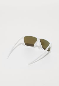 Occhiali da sole bianchi con un design angolare, lenti verde scuro e una finitura texturizzata sulle stecche. Logo "Bliz" sul lato.